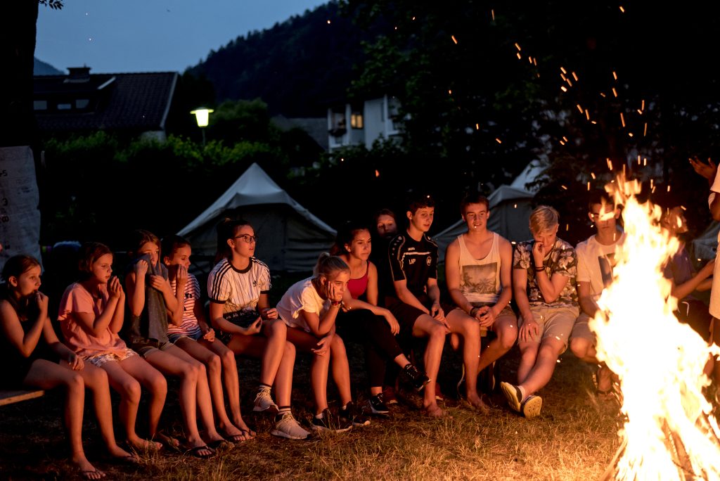 Eine Gruppe sitzt vor einem Lagerfeuer