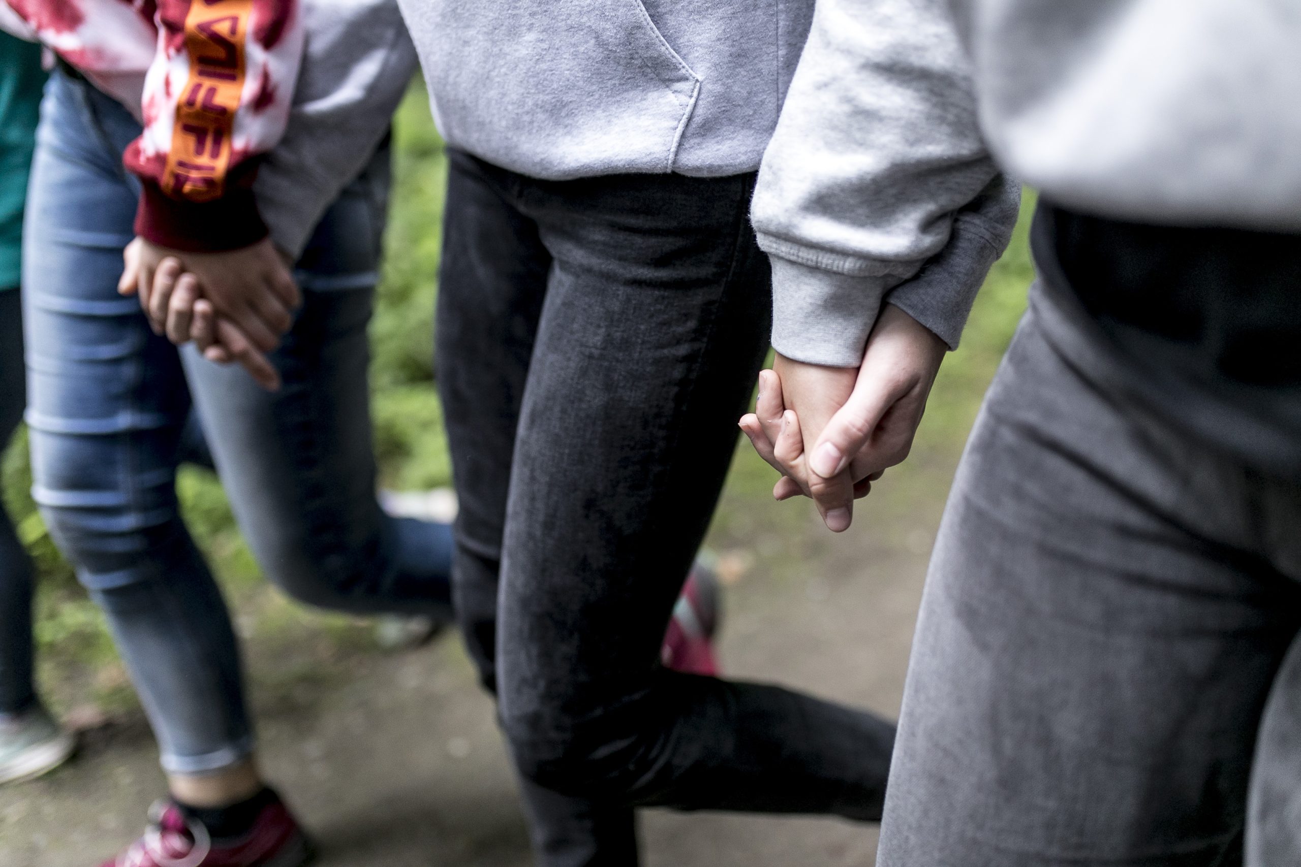 Eine Gruppe Jugendliche, die Hand in Hand laufen
